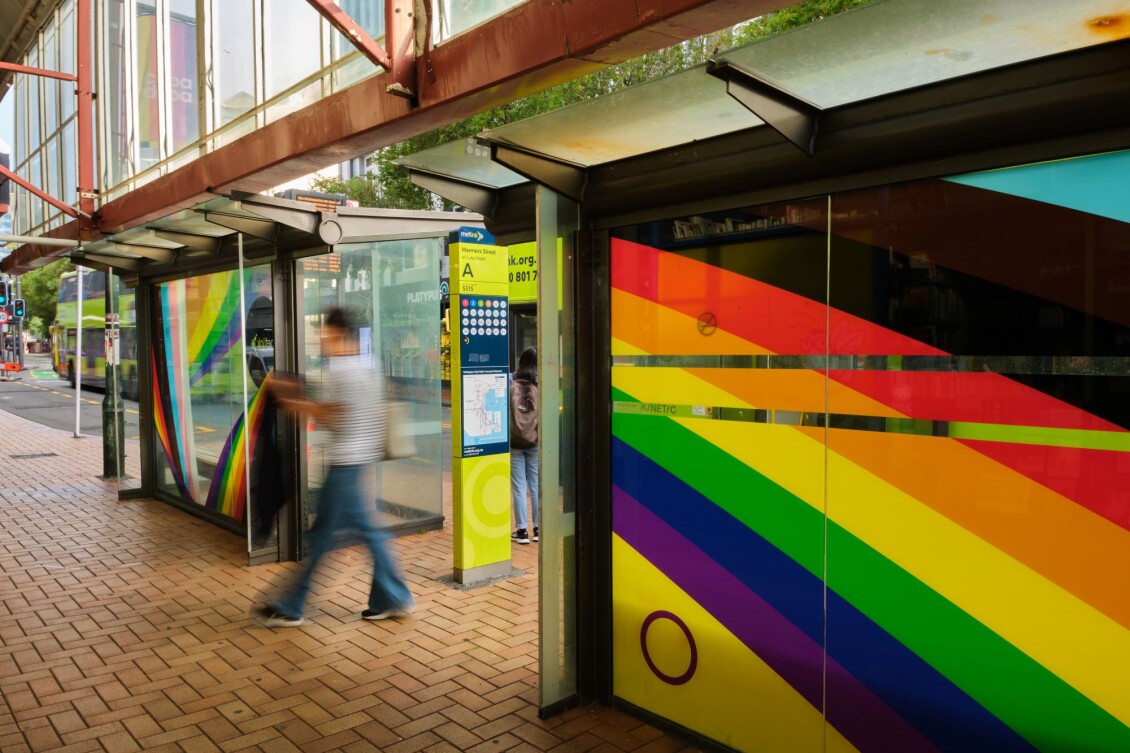 The rainbow bus stop at Manners St, with colours of the progress pride flag curving across it